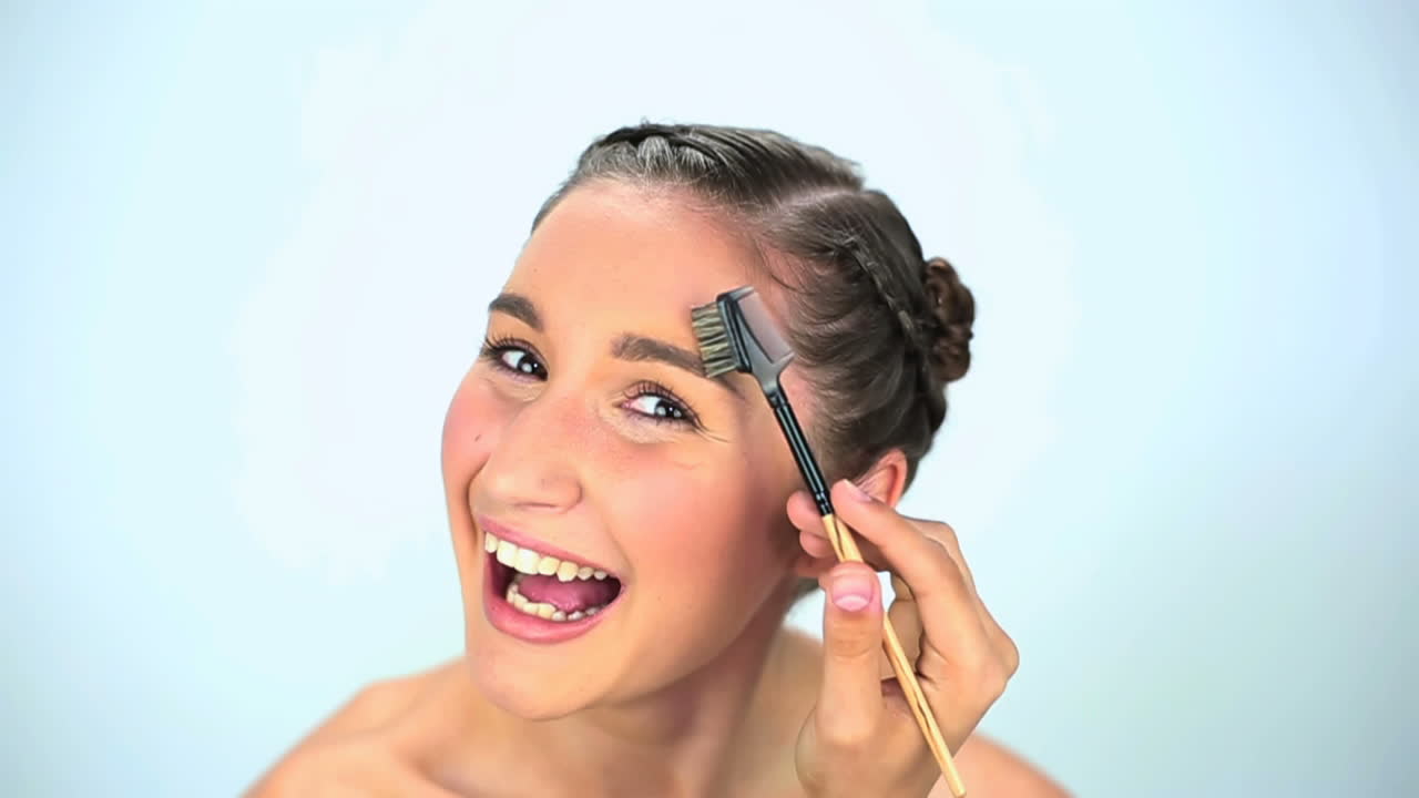 Young woman brushing her eyebrow 