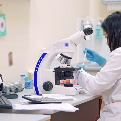 young woman doing analysis in the laboratory near the microscope. conducting research in laboratory with a microscope.