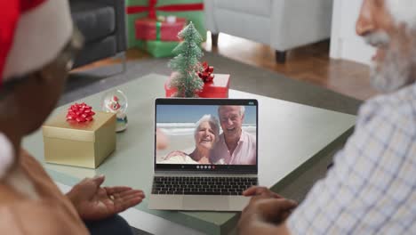 Happy-senior-african-american-couple-on-video-call-with-friends-at-christmas-time