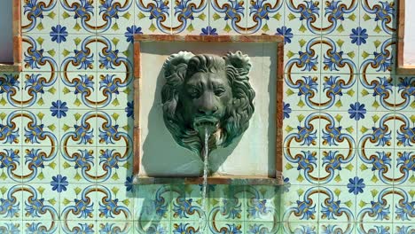 fuente de agua de cabeza de león con hermosos azulejos en una típica ciudad española de estepona