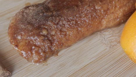sweet cinnamon-flavored torrijas with syrup dripping down on a wooden surface