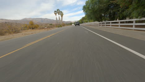 acrobático cinemático fpv drone disparo persiguiendo un nuevo coche de policía a lo largo de una carretera
