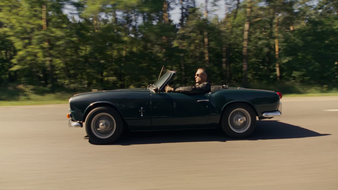 Man Driving a Classic Convertible on a Road
