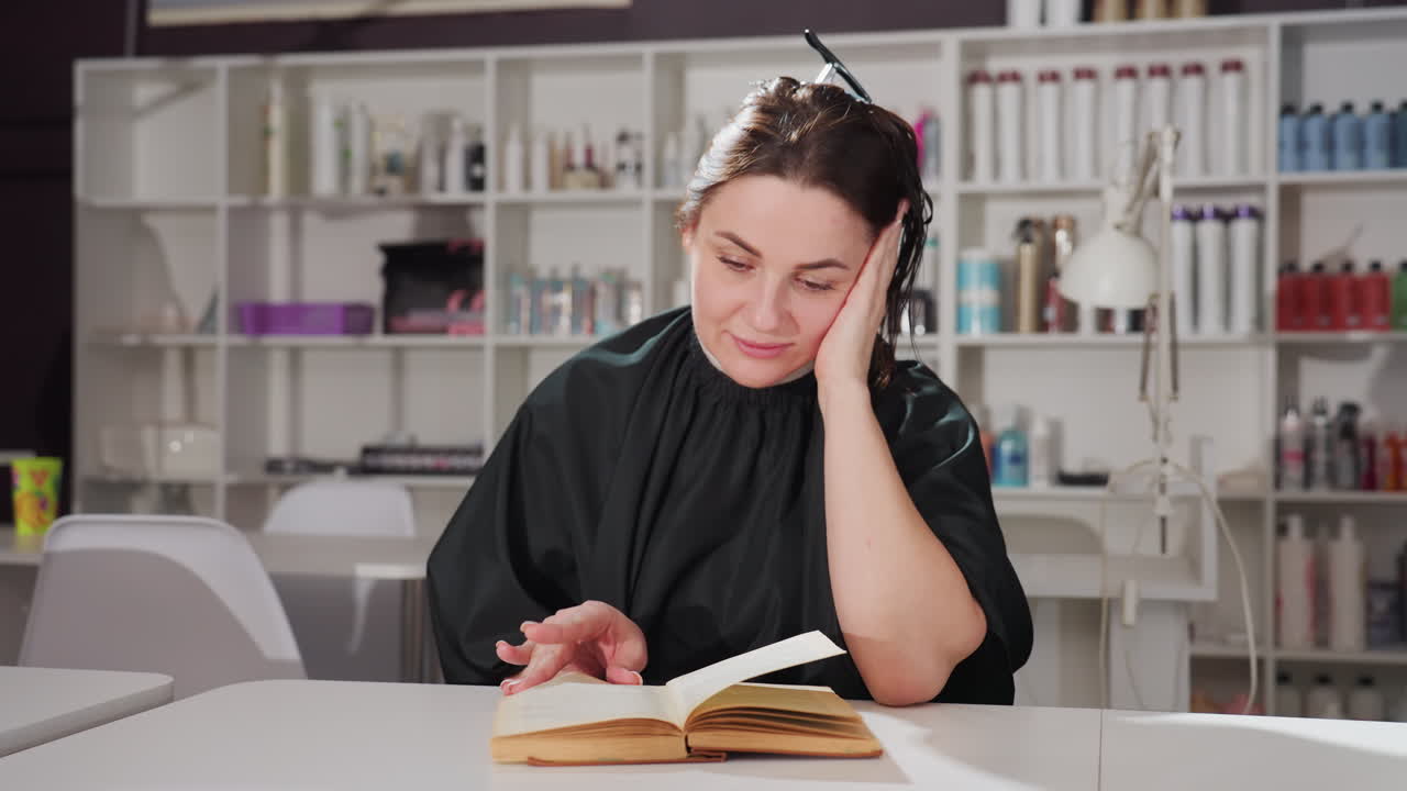 Un experto en belleza examina inspiraciones de colecciones, un peluquero profesional revisa muestras de la biblioteca para nuevos estilos, un estilista de moda investiga la biblioteca del salón en busca de próximas tendencias e ideas para colecciones