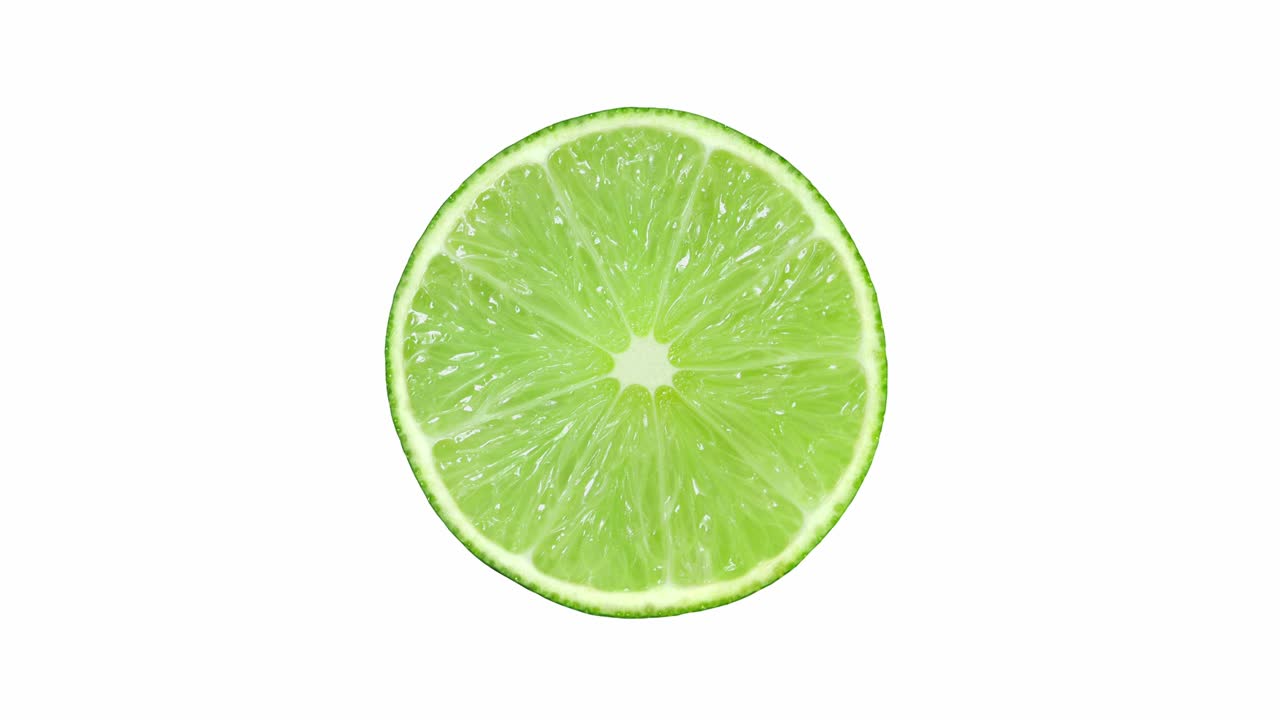 frutas cítricas de lima, cortadas en el medio, girando sobre un fondo blanco, vista de arriba.