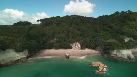 Cinematic-scenic-flight-into-the-rock-face-of-Cathedral-Cove,-New-Zealand