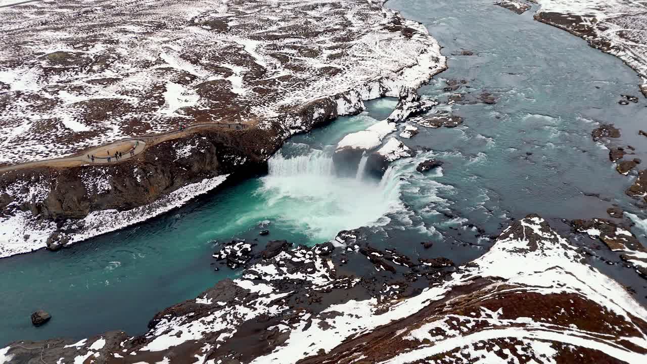 drone rotate around Waterfall of the Gods Goðafoss in Iceland , famous travel destination , valley covered in snow winter white landscape