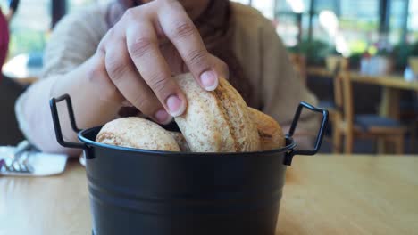 mujer disfrutando de panes frescos en un restaurante