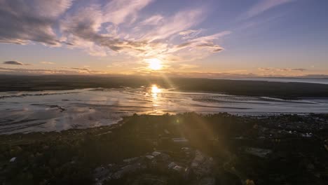 toma aérea con el sol reflejado en el océano con una impresionante puesta de sol