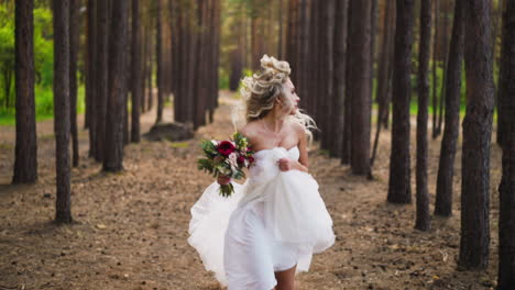 Bride-in-dress-with-bouquet-runs-looking-back-in-wood