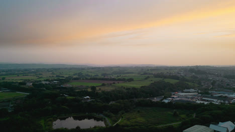 Experience-Heckmondwike,-UK,-through-captivating-drone-shot-aerial-footage,-highlighting-industrial-structures,-lively-streets,-and-the-historic-town-center-during-a-summer-evening