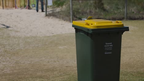 stationary recycling bin on grassy area near beach