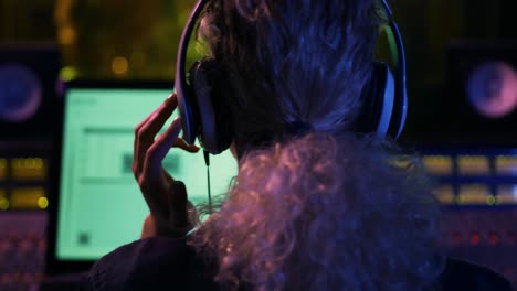 Female-sound-engineer-working-at-a-mixing-desk