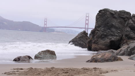 Langsame-Wellen-Brechen-Immer-Wieder-Auf-Einen-Leeren-Strand,-Nebligen-Tag,-Golden-Gate-Bridge