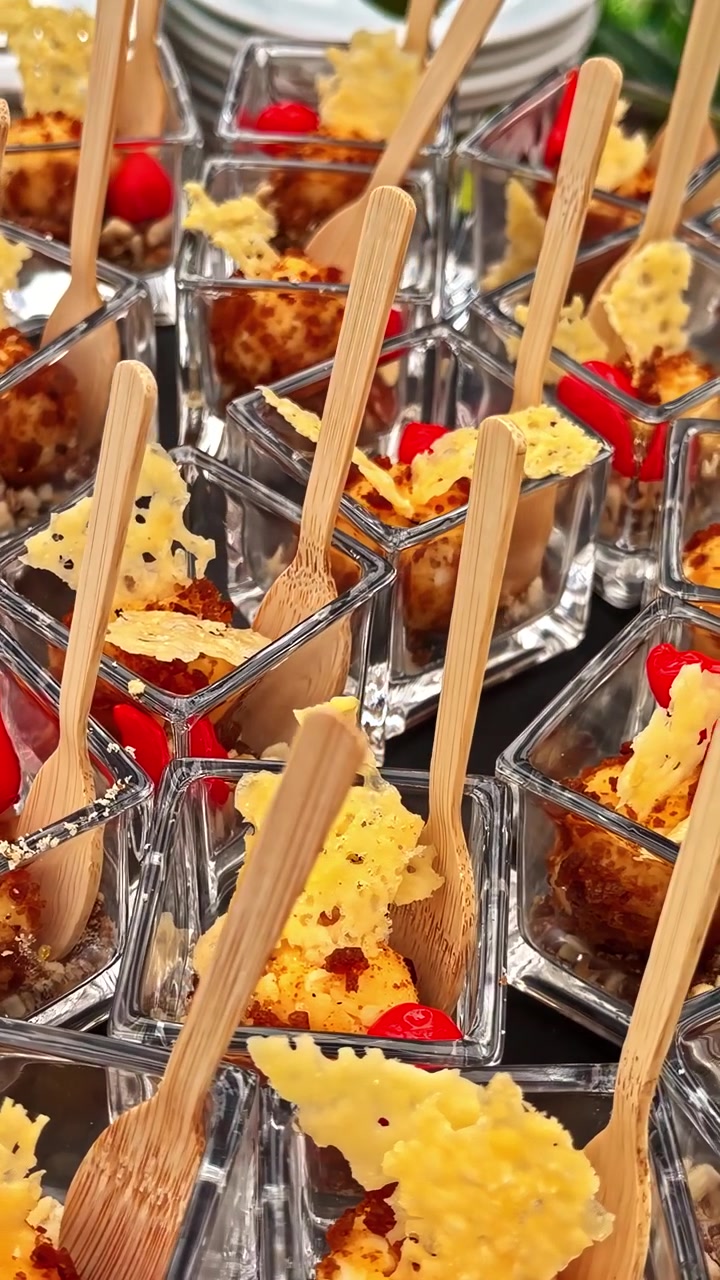 Porzioni individuali di antipasti in coppette di vetro con forchette di legno a un evento con catering.