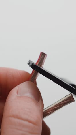 man cutting two wires with wire strippers. close up