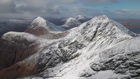 drone panning shot of the red cuillin mountains in winter time on a sunny day in scotland