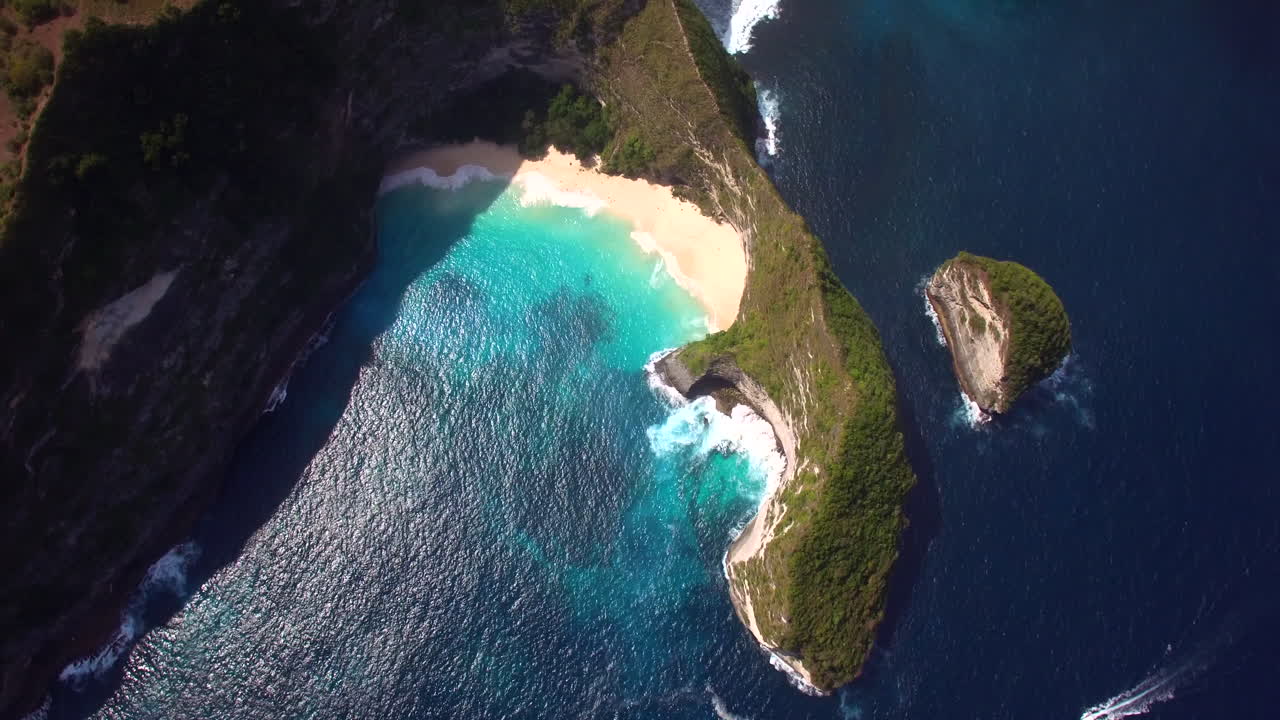 drone volando hacia adelante sobre la playa de kelingking en la isla de nusa penida península verde arena amarilla