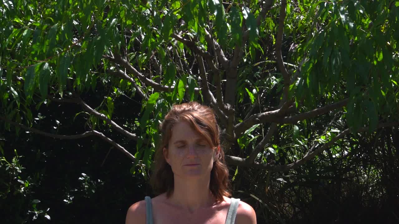 toma en cámara lenta de una joven caucásica pelirroja respirando durante su práctica de yoga matutina