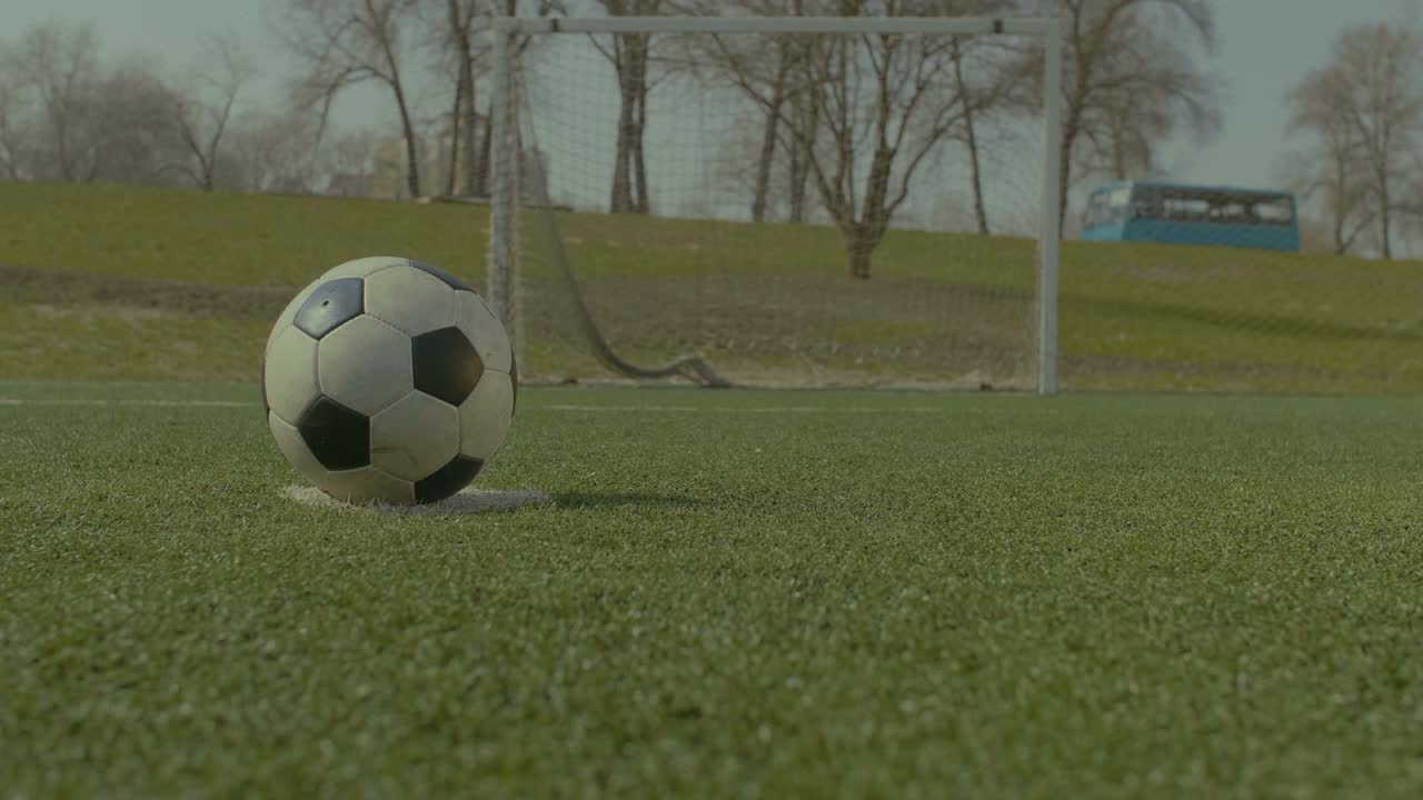 Fodboldspiller udfører straffespark under træning.