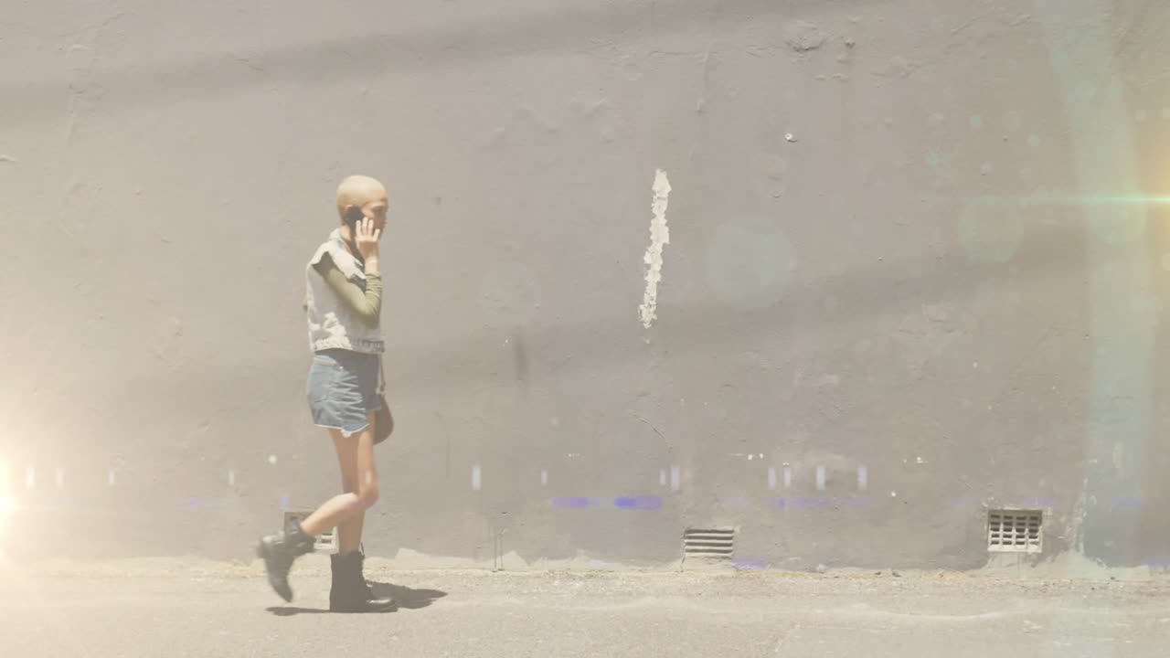 거리에서 스마트폰을 사용하여 일하러 가는 두 인종의 여성 위에 있는 색 ⁇ 의 불빛의 비디오