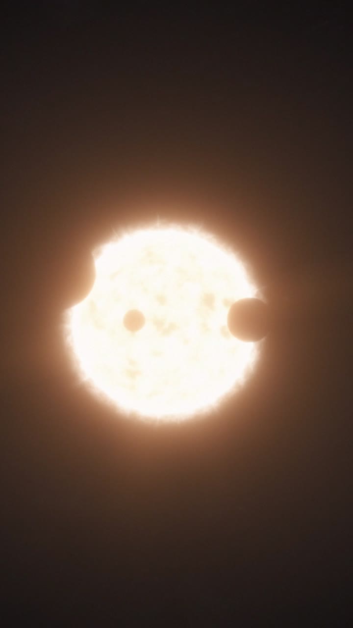 Vertical Medium Shot of a Hot Orange Glowing Star as Multiple Planets Cross the Face of the Sun