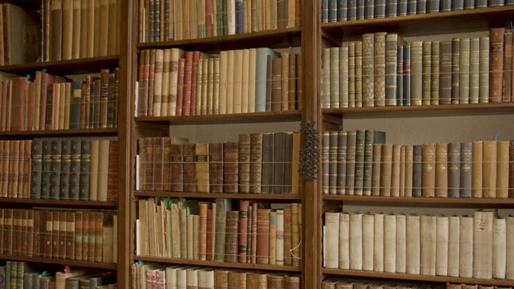 Carrellata verso il basso su una collezione di libri antichi in una lussuosa biblioteca privata