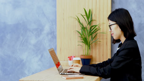 Businesswoman-using-laptop-at-desk-4k