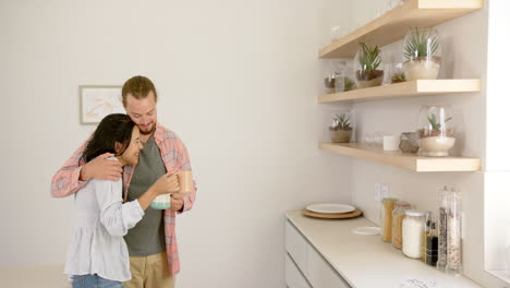 a diverse couple shares a moment in a modern kitchen at home, copy space