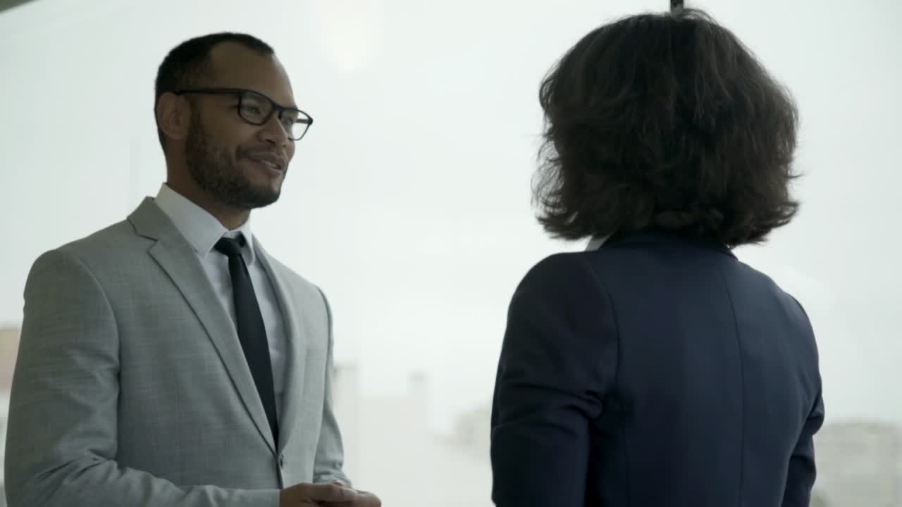 gerentes sonrientes reuniéndose cerca de la ventana.