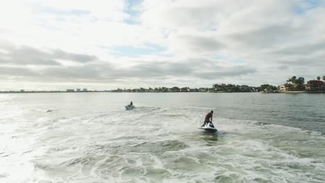 two wave runners moving very fast under a cloudy sky