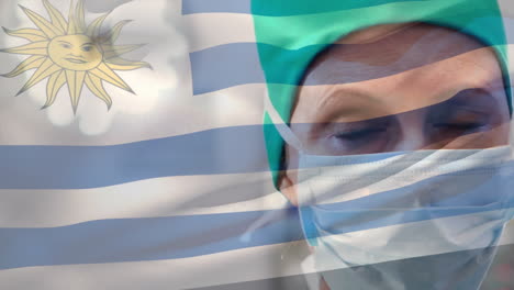 animación de agitar la bandera uruguaya contra una cirujana caucásica con máscara quirúrgica en un hospital