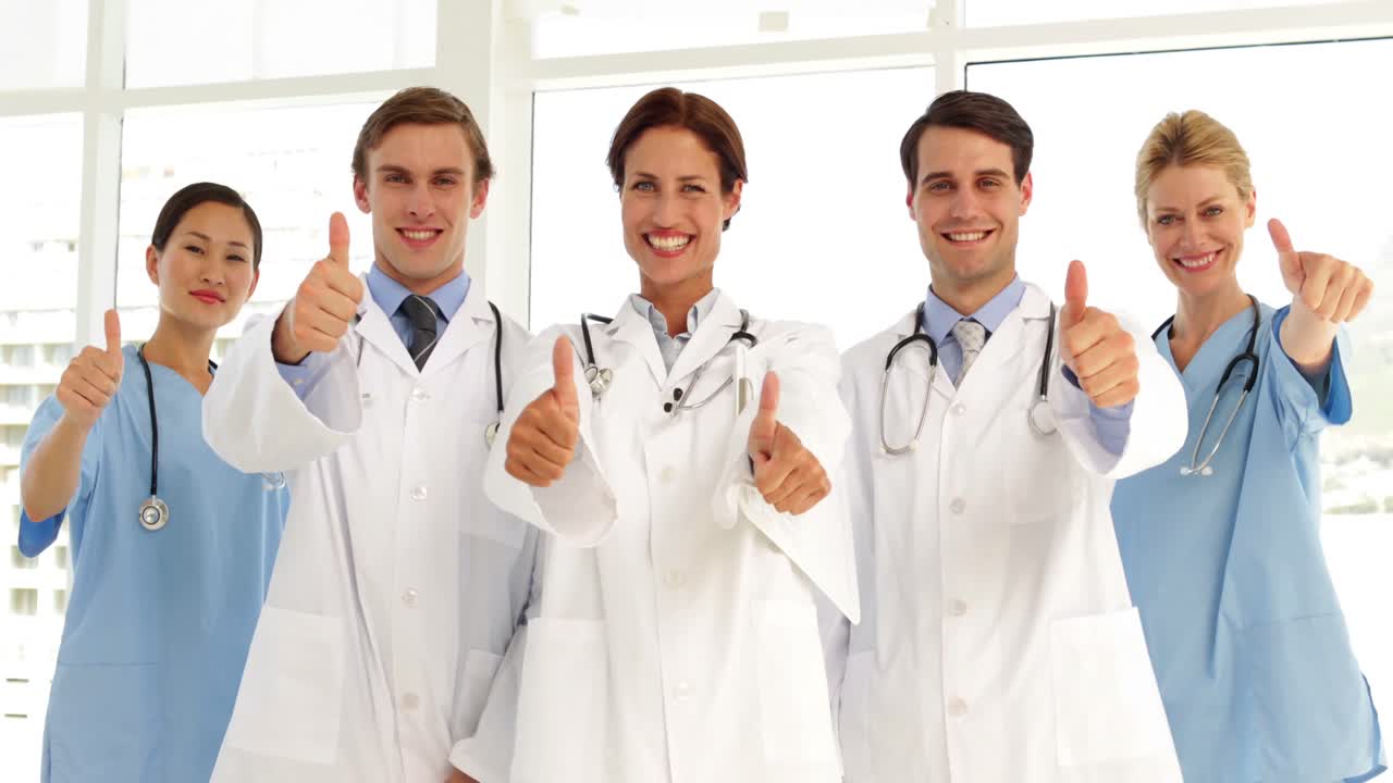 Confident medical team looking at camera and giving thumbs up