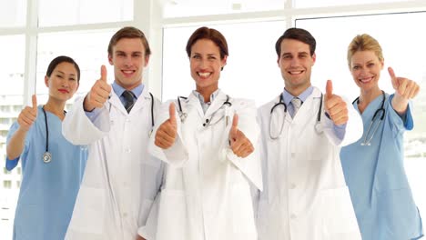 Confident-medical-team-looking-at-camera-and-giving-thumbs-up