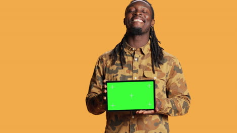 male model holding laptop with greenscreen layout in studio