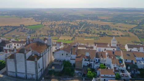 vuelo de drones sobre el castillo de monsaraz hacia campos en el paisaje de alentejo, portugal