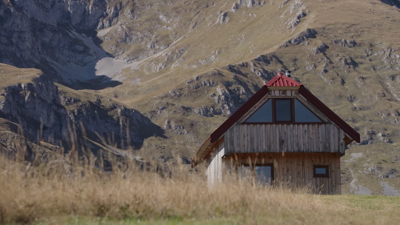 Wooden winter ski cabin at Durmitor National Park with mountain backdrop, Static shot