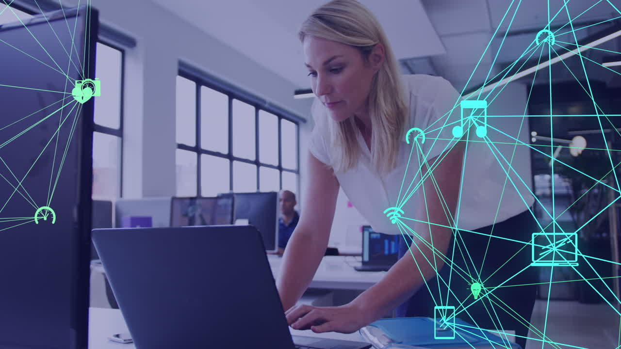 animación de dos globos de iconos digitales girando contra una mujer caucásica usando una computadora portátil en la oficina