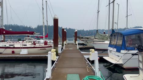 Jetty-With-Anchored-Boats-At-The-Harbour-Near-Coastal-City-Of-Florence,-Oregon,-USA