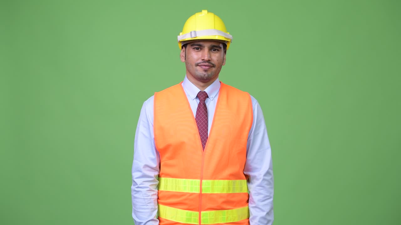 Young handsome Persian man construction worker pointing at camera