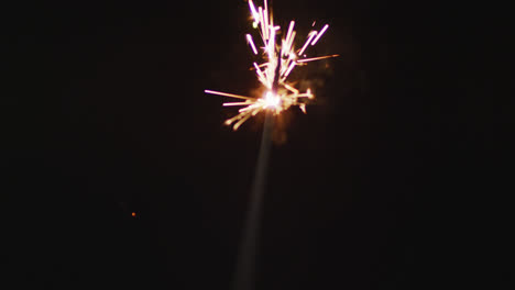 video de un centelleador encendido quemándose sobre un fondo negro, con espacio para copiar