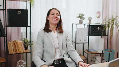 business woman freelancer takes break leaning on chair after working celebrating success victory win