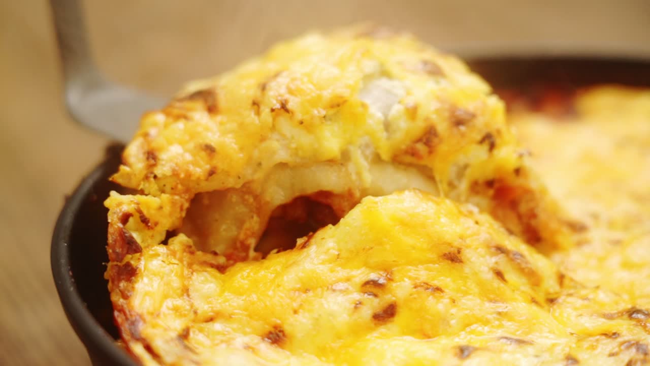 cocinero irreconocible cortando un delicioso gratin con verduras y salsa de tomate