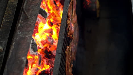 slow motion of male hands wearing gloves placing meat beef steaks on the grill with red hot flaming charcoal