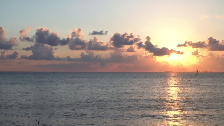 Sunset over the Ocean with Sailboat