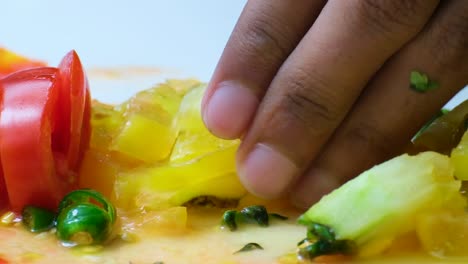 Close-up-clip-of-hand-holding-vegetables-and-knife-cutting-them-finely-to-make-salsa