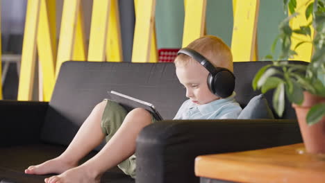 young boy listening to music on tablet