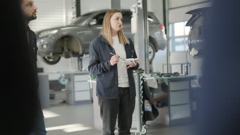 female manager discussing vehicle repair with mechanic in auto repair shop