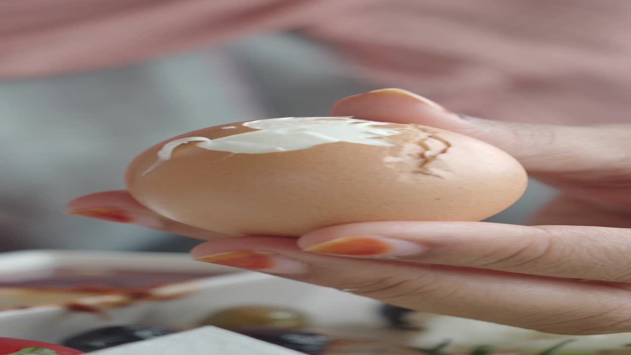 Woman peeling a boiled egg