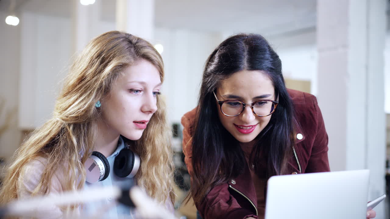 mujeres colaborando en el trabajo de la computadora portátil